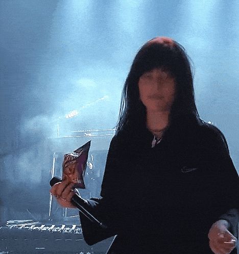 a woman in a black nike shirt holds a bag of chips in her hand