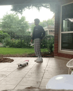 a person standing on a patio with a skateboard on the ground