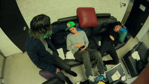 a group of people sitting on a couch with the letter d on the bottom right