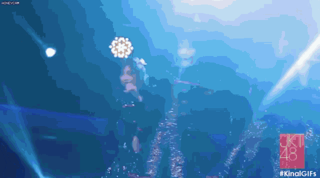 a woman singing into a microphone on a stage with a blue background