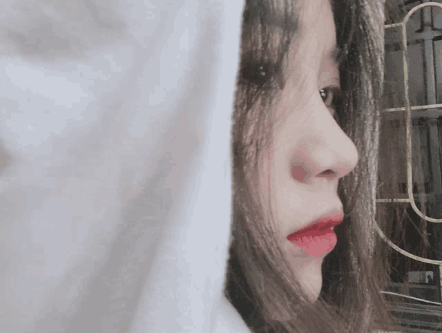 a close up of a woman 's face with a white hoodie over her head