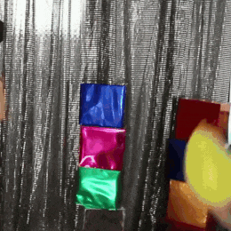 a person is blowing up a balloon in front of a stack of boxes