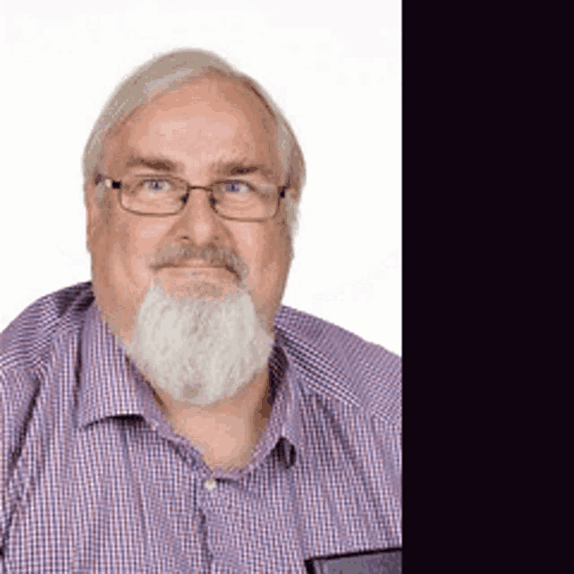 a man with glasses and a beard wears a plaid shirt