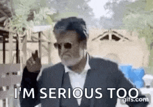 a man wearing sunglasses and a suit is making a funny face and saying `` i 'm serious too '' .