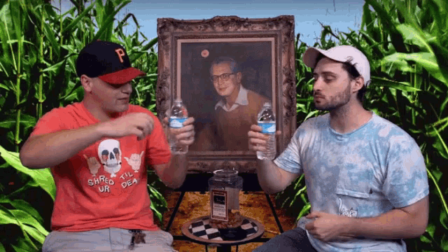 a man wearing a shirt that says shred the dead holds a bottle of water