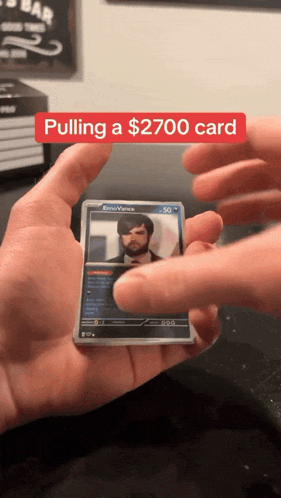 a person is pulling a $ 2700 card from a stack