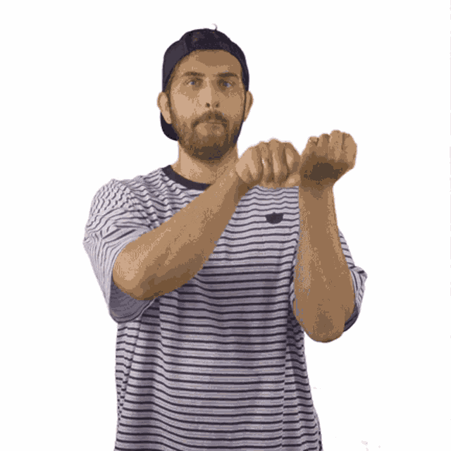 a man wearing a striped shirt and a hat shows his middle finger