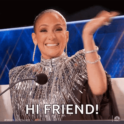 a woman in a silver dress is sitting in front of a microphone saying hi friend