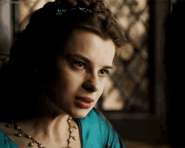 a close up of a woman wearing a pearl necklace and a braid