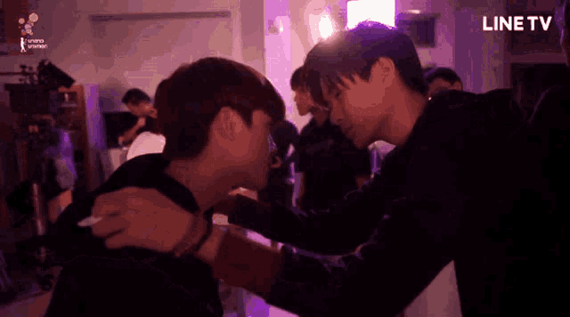 a group of young men are hugging in front of a line tv logo