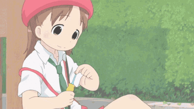 a little girl in a red hat is eating something with a spoon