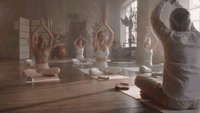 a group of people are practicing yoga in a room