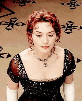 a woman wearing a black dress and white gloves is looking down