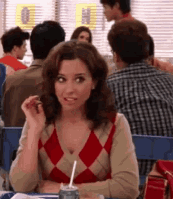 a woman is sitting at a table with a can of soda .