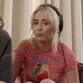 a woman wearing headphones is sitting on a couch .
