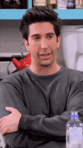 a man with his arms crossed is sitting at a table with a bottle of water in front of him