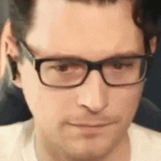 a man wearing glasses is making a funny face .