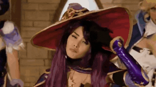 a woman with purple hair is wearing a witch costume and a hat .