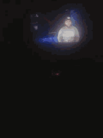a blurred image of a person in a dark room with a blue background