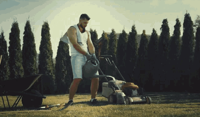a man is watering a lawn mower with a hose