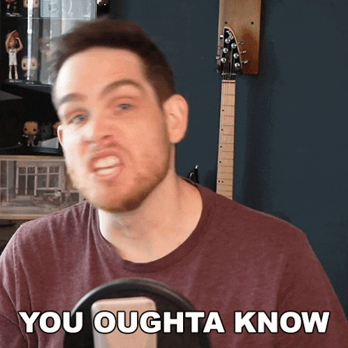 a man with a beard says you oughta know in front of a guitar
