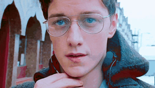 a close up of a man wearing glasses and a jacket