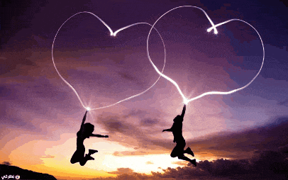 a couple of people jumping in the air making a heart shape