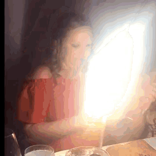 a woman in a red top is sitting at a table