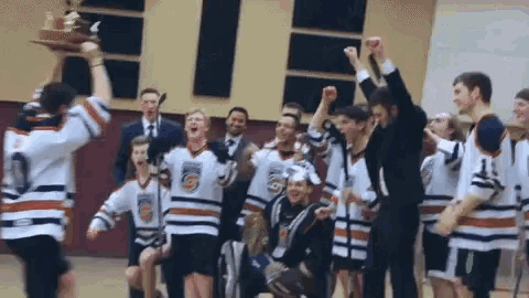 a hockey team celebrates with a trophy and the number 5 on their shirts