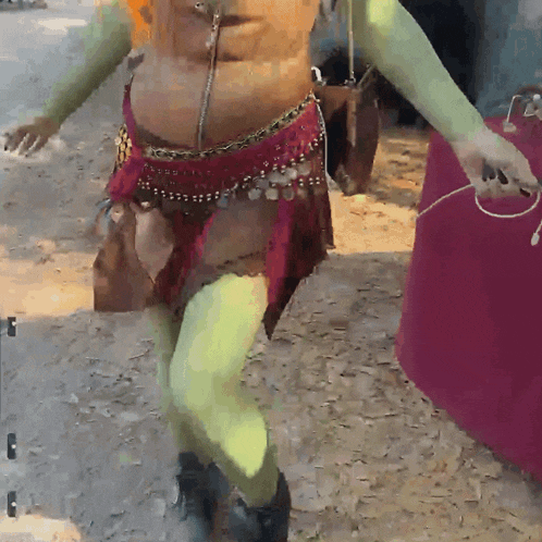 a woman in a shrek costume is dancing on the ground