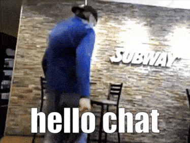 a man standing in front of a subway sign
