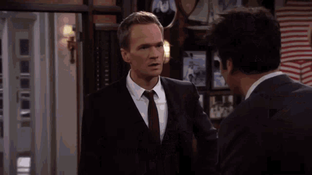 a man in a suit and tie is talking to another man who is asking if he is moving to chicago
