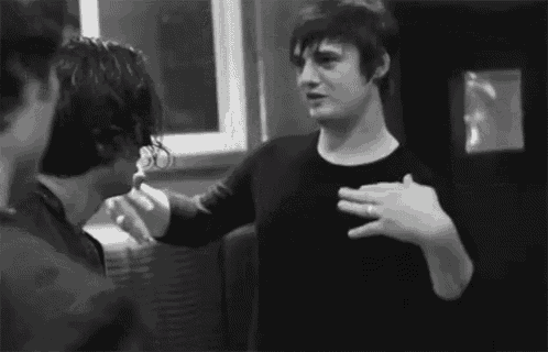 a man in a black shirt is talking to another man in a black shirt