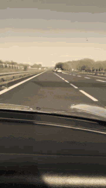 a car is driving down a highway in a sepia tone photo