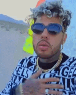 a man wearing sunglasses and a sweater with the word angels on it .
