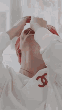 a man wearing a red hat and a white shirt covering his face with his hands