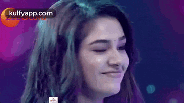 a close up of a woman 's face with her eyes closed smiling .