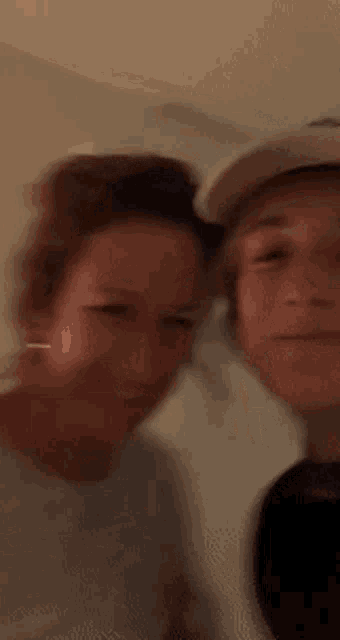 a man and a woman are posing for a picture and smiling for the camera .