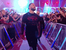a man wearing a t-shirt that says xtc is walking through a crowd of people