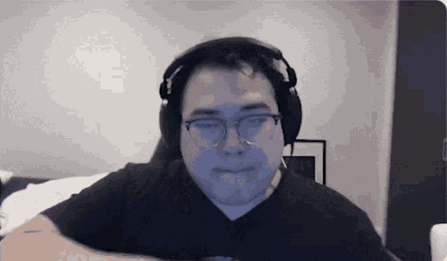a man wearing headphones and glasses is looking at the camera
