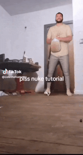 a man is standing in a room with a milk jug in his hand and a caption that says " pss nuke tutorial "