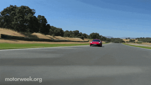 a red sports car is driving down a road with motorweek.org written on the bottom right