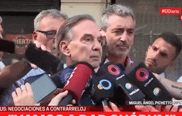 a group of men are talking into microphones in front of a sign that says ' eldiario ' on it
