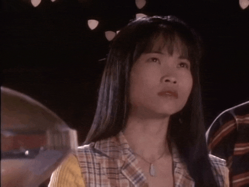 a woman in a plaid shirt is standing in front of a sign that says i don 't