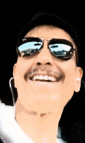 a man with a mustache wearing sunglasses and headphones is smiling