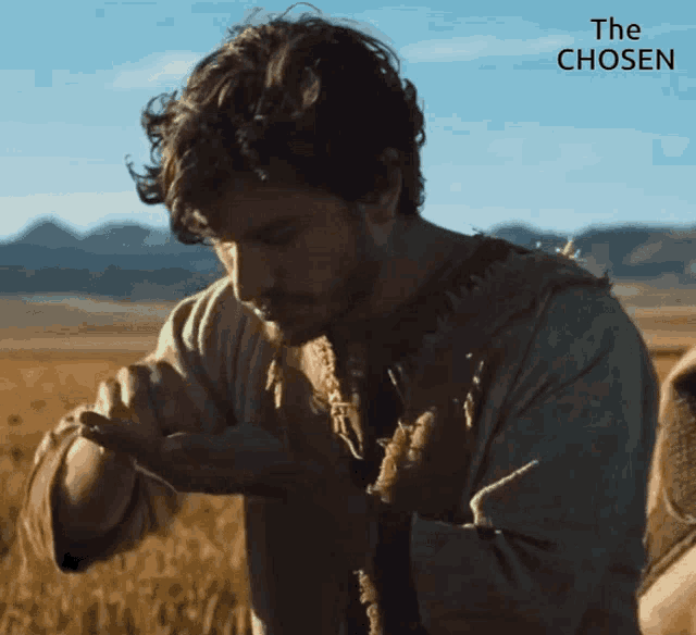 a man standing in a field with the words " the chosen " above him