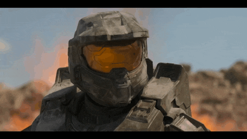 a close up of a halo soldier 's helmet with a fire in the background