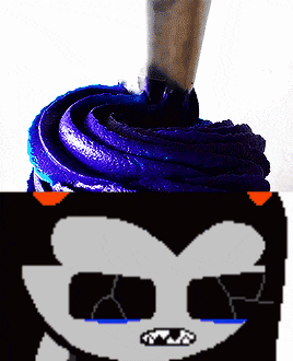 a cupcake with purple frosting and a drawing of a cat with sunglasses