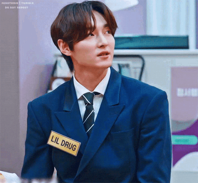 a man in a suit and tie has a name tag that says lil drug on it