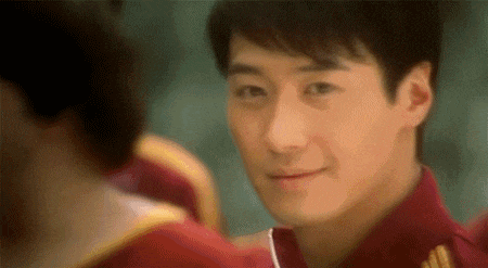 a close up of a man in a red shirt looking at the camera .